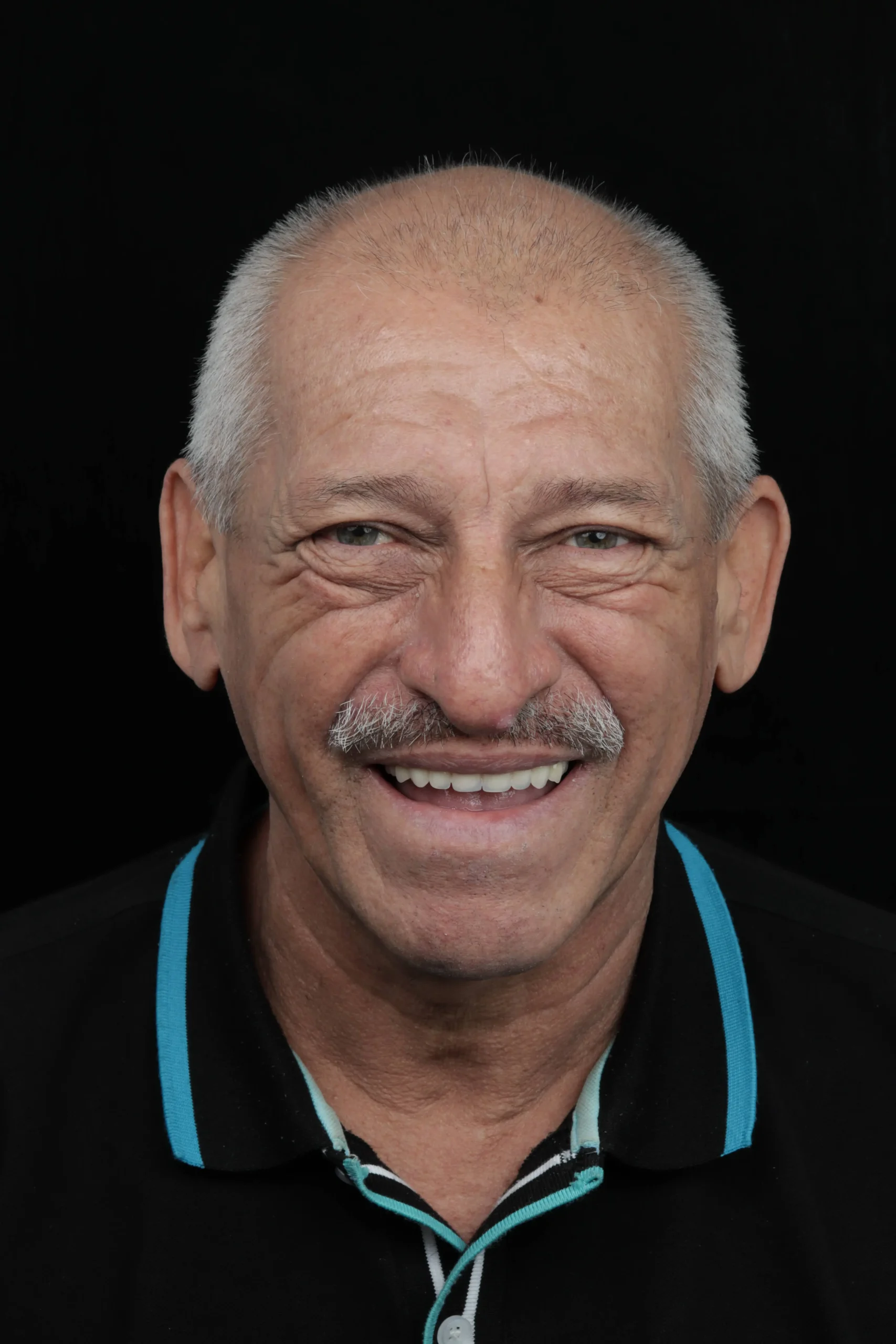 Paciente adulto mayor sonriente después de un tratamiento de rehabilitación oral con prótesis dentales funcionales y estéticas